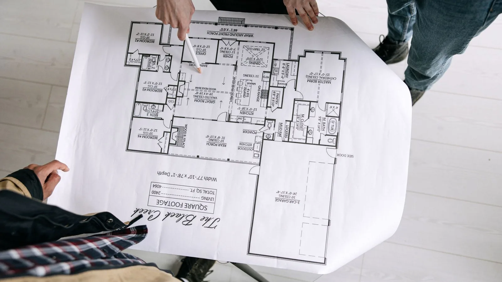 Osoba trzymająca plan mieszkania z rzutem pomieszczeń